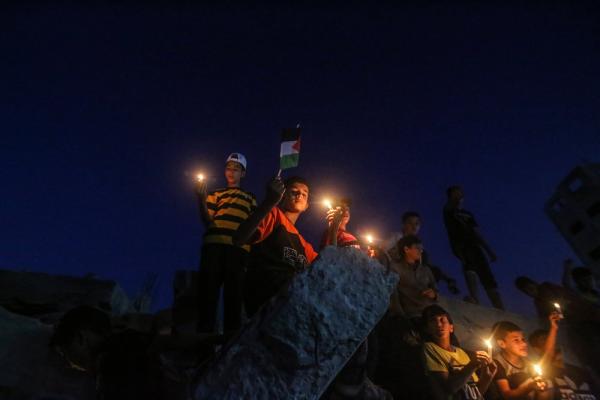 Palestinian children hold candles at a vigil for those killed in Israel's bombardment of Gaza.