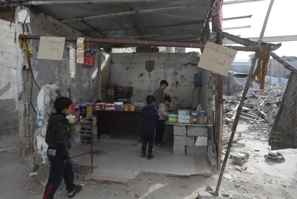 Palestinian children, many of whom suffer from malnutrition, sell goods at a market to help support their families.