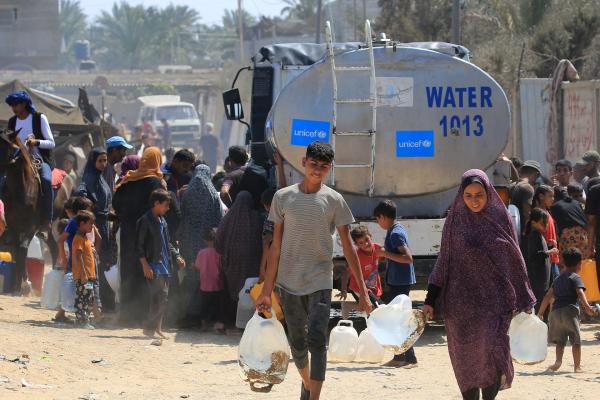 Palestinians collect water provided by UNICEF in Deir al-Balah, Gaza Strip in 2024.