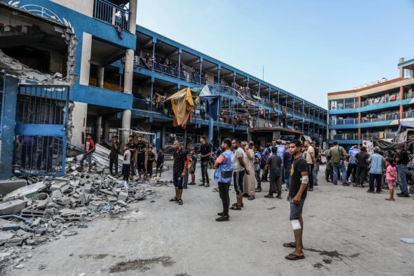 Palestinians inspect the damage to an UNRWA school in Gaza's Nuseirat refugee camp.