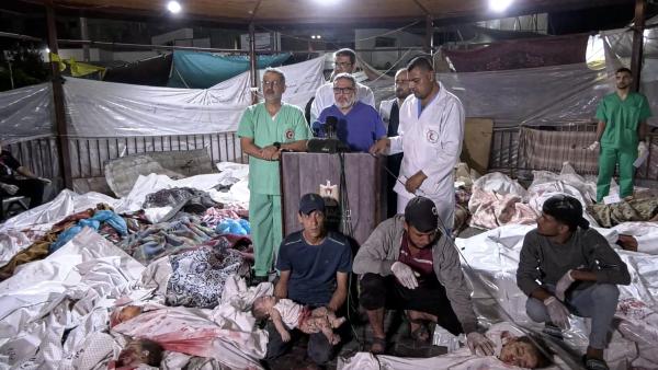 Dr. Ghassan Abu-Sittah and other doctors at Gaza City's Al-Ahli Baptist Hospital speak at a press conferences surrounded by the bodies of victims of Israel's October 17, 2023 attack on the hospital.