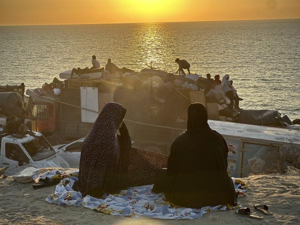 Palestinian women look on at the sunset over the Mediterranean Sea at a beach in Gaza. September 18, 2025.