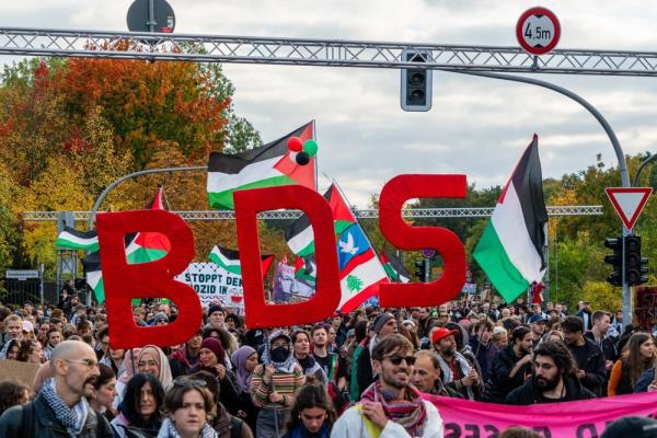 At a large Palestine solidarity protest in Germany against Israel's war on Gaza, protestors carry Palestinian flags and the letters BDS.