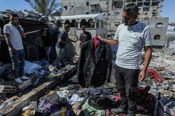 A man carries the suit of Muhannad Othman Farwana, a groom, amid the rubble after an Israeli airstrike on Khan Yunis. Farawna, the groom, was killed in the Israeli airstrike just hours before his wedding was set to take place. June 9, 2026.