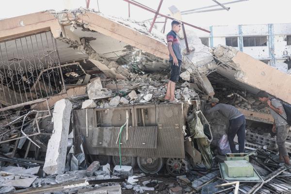 Palestinians in Gaza City's Tel al-Hawa neighborhood inspect rubble and ruins of a building in Gaza which has collapsed over Israeli military vehicles and ammunition left behind following the Gaza ceasefire. October 11, 2025.