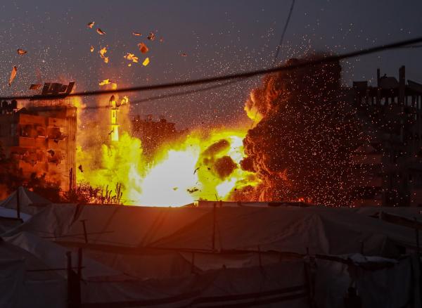 View of flames and smoke rising due to an Israeli airstrike on the al-Muttaqin Mosque, nearby buildings, and a nearby displacement tent encampment in Gaza City's Yarmouk neighborhood. July 28, 2026.