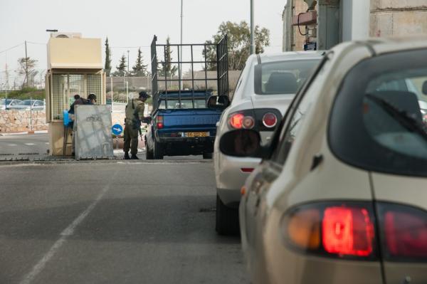 Israeli soldiers hold a line of Palestinian cars at a checkpoint in the West Bank.