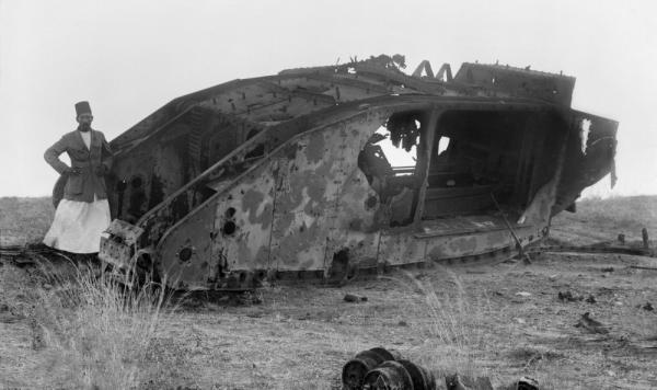 A Palestinian man stands near a destroyed British tank in Gaza during a battle between British and Ottoman forces during World War I. 1917.