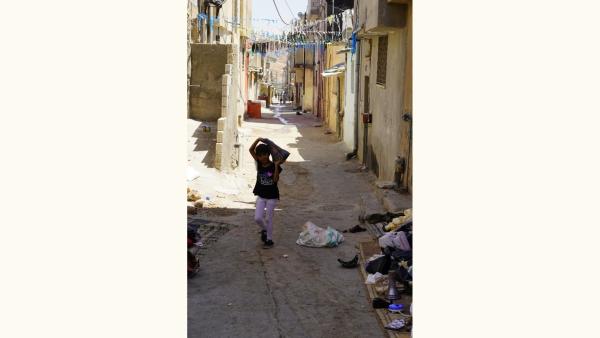 A young girl walks down the street in an UNRWA refugee camp in Jerash, Jordan.