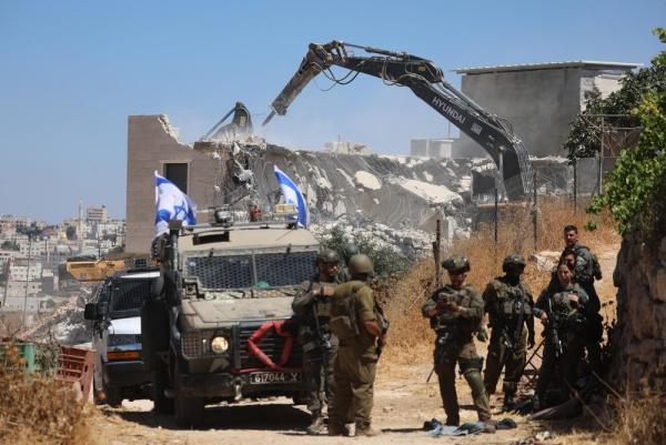 The Israeli military destroys a Palestinian home in the village of Qalqas near Hebron using Hyundai equipment.