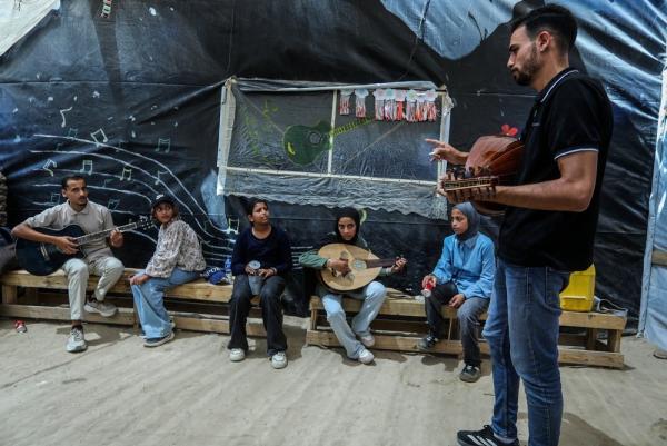 In a music class for displaced Palestinians in the Gaza Strip, girls learn to play the oud and guitar.