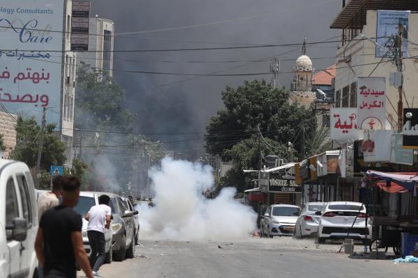 Palestinians react back to Israeli forces who killed at least 9 and injured 50 Palestinians, 8 of which were killed during the airstrikes and raid in Jenin, West Bank on July 03, 2023.