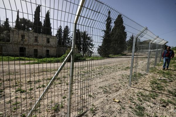 Palestinian Ameed Dusouki, a member of the Burqa village council, walks along a fence installed by Jewish settlers after they announced their control over the historical Al-Masoudiya Ottoman era train station, which operated between the Palestinian cities of Nablus and Tulkarm in the 1920s, just north of the city of Nablus, in the northern Israeli-occupied West Bank on February 15, 2026