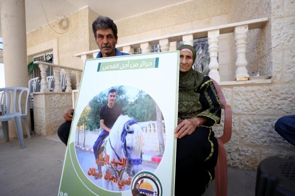 Family of 19-year-old Qusay Jamal Matan, who killed by Israeli settlers in gun attack, hold a poster with a picture of Matan in Burka village of Ramallah, West Bank on August 09, 2023. 